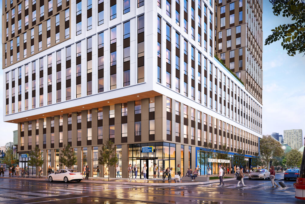 Corner view of a modern building with ground-floor retail, pedestrians, and a streetcar along a busy urban street.